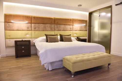 a large bedroom with a large bed and a stool at Hotel Denver Mar del Plata in Mar del Plata