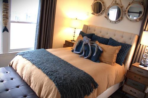 a bedroom with a large bed with pillows and mirrors at The Pelican Pass in Freeport