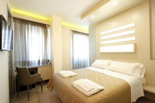 a bedroom with a bed and a desk and a window at Chez Moi Tropea Centro in Tropea