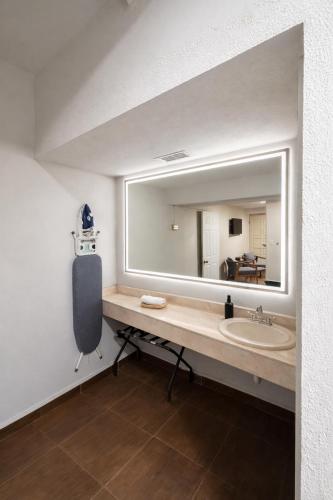 a bathroom with a sink and a large mirror at HOTEL LOS ROBLES in Nuevo Laredo
