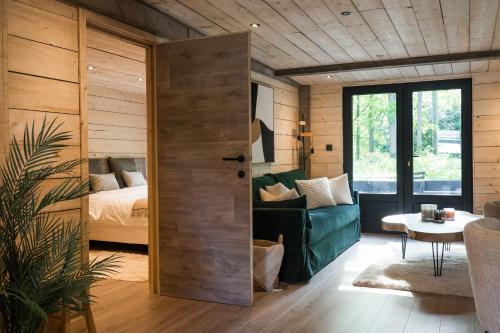 a room with a bed and a door leading to a bedroom at Wood Chalet Durbuy in Durbuy