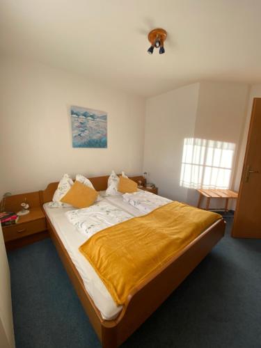 a bedroom with a large bed with a yellow blanket at Ferienwohnung Abendsonne in Schenkenfelden
