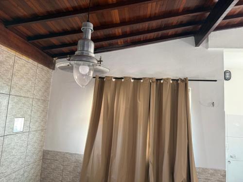 a bathroom with a shower curtain and a ceiling at Duplex Belli a 300m do Mar in Natal