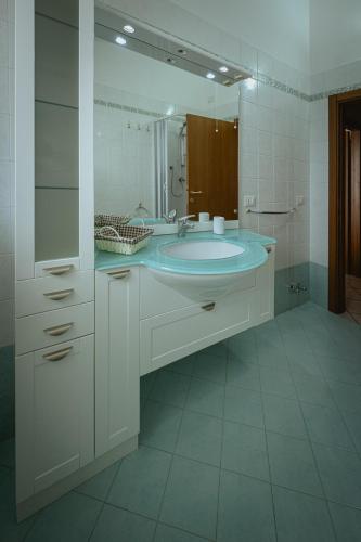 a bathroom with a sink and a large mirror at Orli Home e Relax in Casole dʼElsa