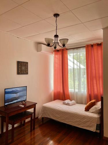 a bedroom with two beds and a table and a window at Casa Esmeralda Boutique Hotel in San José