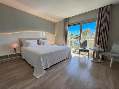 a bedroom with a white bed and a large window at Kalyon Cesme in Çeşme