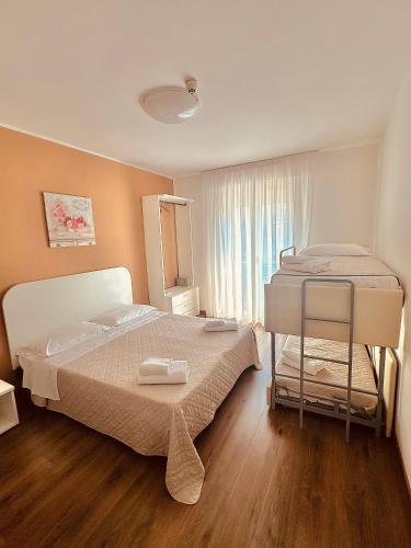 a bedroom with a large bed and a window at Hotel Playa in Bibione
