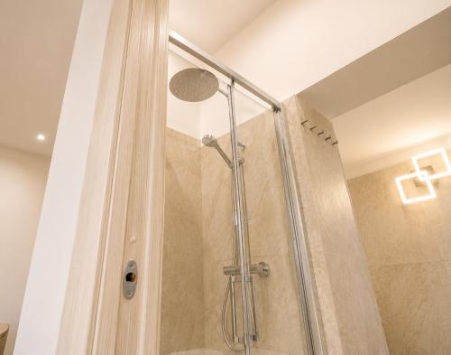 a shower with a glass door in a bathroom at LIGEA APARTMENT - Bright Mediterranean Home with Bali-Inspired Touches - Central Anzio near Sea, Train and Bus Station in Anzio