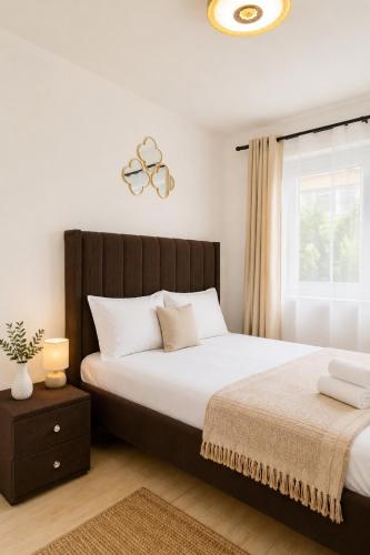 a bedroom with a large bed and a window at Stylish 2BR Apartment Free WiFi Near Nairobi National Park in Ongata Rongai 
