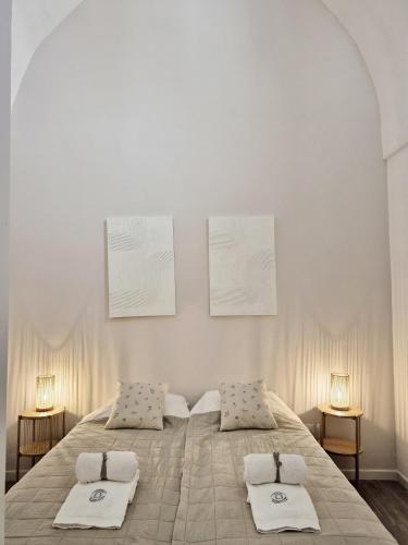 a bedroom with a large bed with towels on it at La Loggia, Historic Center in Grottaglie