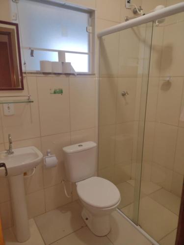 a bathroom with a shower and a toilet and a sink at Hospedaria São Francisco in Cachoeira Paulista