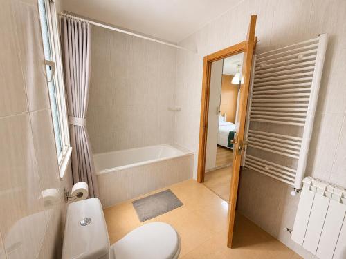 a bathroom with a toilet and a bath tub at Hostal Porta Santiago in Lugo
