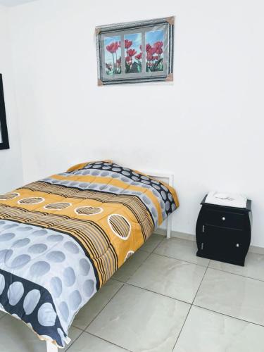 a bedroom with a bed and a picture on the wall at Alojamiento Sabadell Ibarra in Ibarra