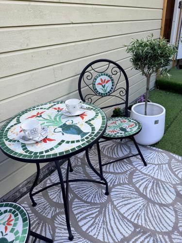 two chairs and a table with a tea set on a patio at Leilighet midt i Sokndal sentrum in Sokndal