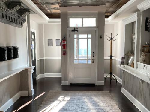 a hallway with a white door and a window at Hotel Laurance in Luray