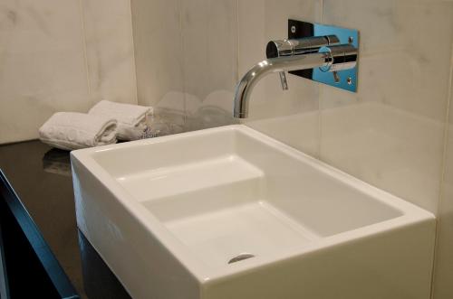 a white sink in a bathroom next to a bath tub at VIP Executive Saldanha in Lisbon