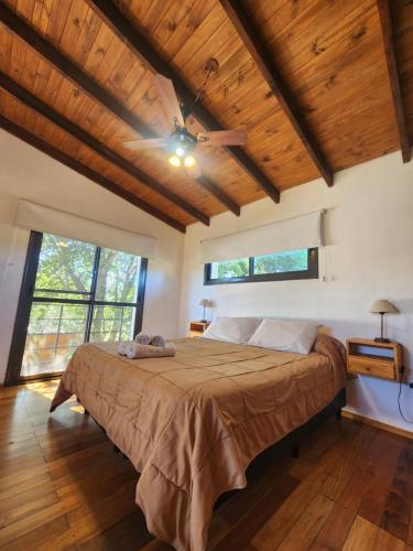a bedroom with a large bed in a room with wooden ceilings at Atardecer Serrano in Villa General Belgrano