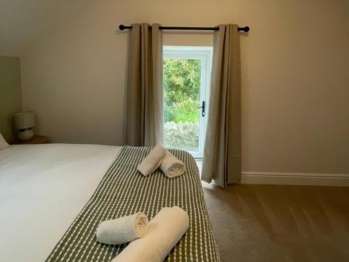 a bedroom with a bed with two towels on it at Storws Tanrallt in Holyhead
