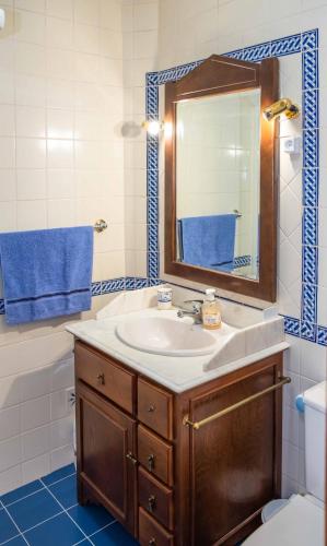 a bathroom with a sink and a toilet and a mirror at Cantinho de Caria in Caria