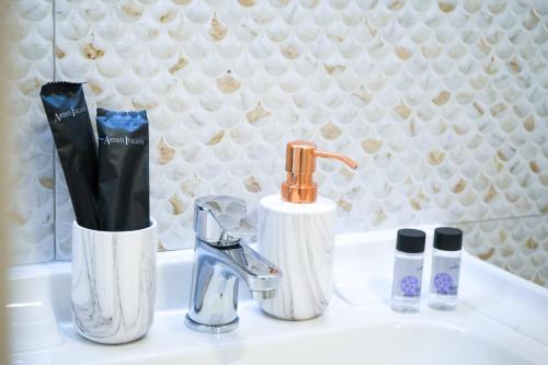 a sink with two toothbrushes and a faucet at Thalassa loft in Tolo in Tolo