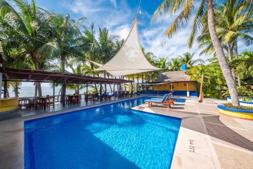 a pool at a resort with palm trees at Hotel Meson de Mita in Punta Mita