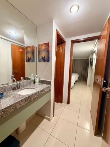 a bathroom with a sink and a mirror at Flat JP Beira mar in João Pessoa