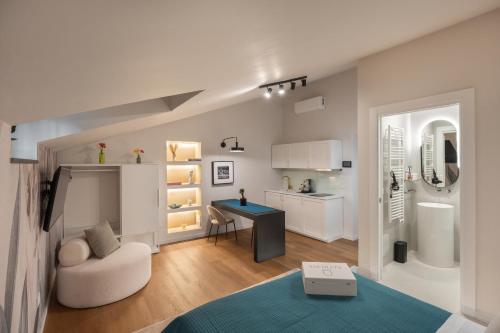 a white living room with a table and a chair at Altrove Boutique Studios in Caserta