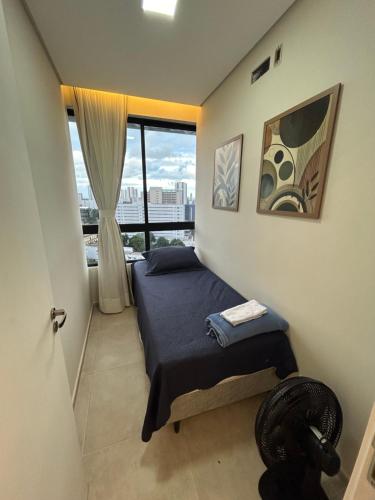 a small bedroom with a bed and a window at Apartamento Max Derby Boulevard in Recife