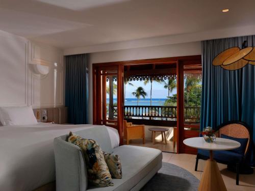 a hotel room with a bed and a view of the ocean at Sofitel Mauritius L'Imperial Resort & Spa in Flic-en-Flac