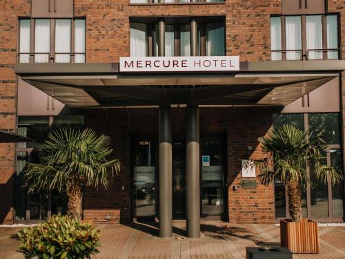 a mercure hotel with palm trees in front of it at Mercure Hotel Hamburg City in Hamburg