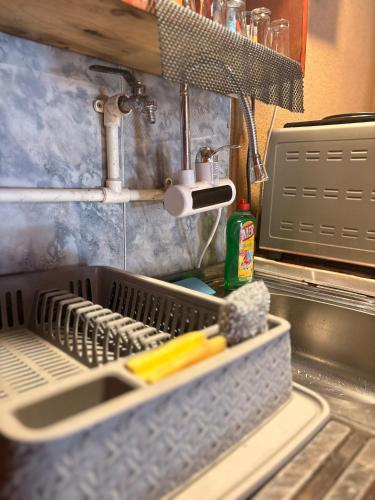 a kitchen sink with a dish drying rack with utensils at Riverside Cabin in Železnička Stanica Ovčar Banja