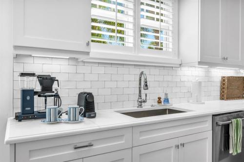 a kitchen with white cabinets and a sink at The Luxe Sunshine Villa w Private Pool House in West Palm Beach