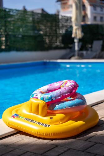 two inflatables on a raft next to a swimming pool at Vila Katalina Spa & Resort in Zlatibor