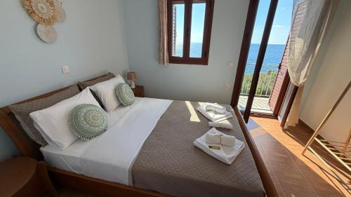 a bedroom with a bed with a view of the ocean at Ticallisti Rooms by Villa Lagkadaki in Agriliá