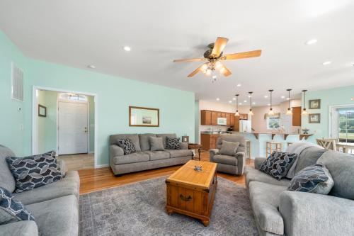 a living room with two couches and a table at Fairway Stay in Greenbackville