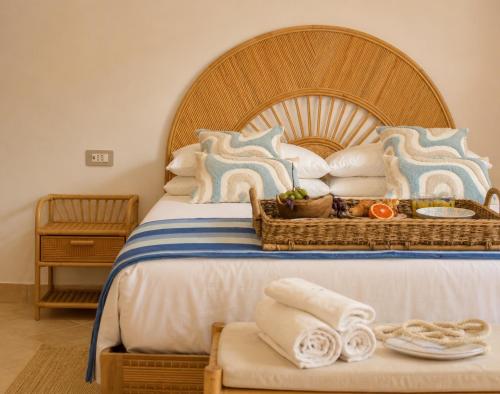 a bedroom with a large bed with a wooden headboard at LIGEA APARTMENT - Bright Mediterranean Home with Bali-Inspired Touches - Central Anzio near Sea, Train and Bus Station in Anzio