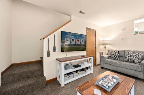 a living room with a couch and a tv at Fishhook Hideaway in Chincoteague