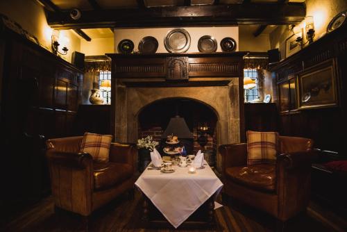 a dining room with a table and chairs and a fireplace at Holdsworth House Hotel in Halifax