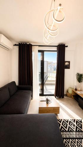 a living room with a couch and a chandelier at Ambra Luxury Suite 14 in Kallithea Halkidikis