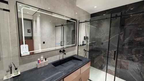 a bathroom with a sink and a shower at Zafran Smart Luxury Suite in Dushanbe