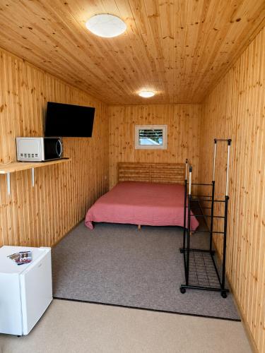 a bedroom with a bed in a wooden cabin at Pool Hause Palanga in Palanga