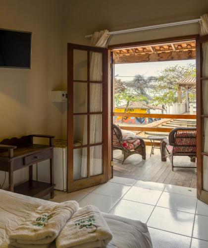 a bedroom with a door open to a patio at Geko Pousada Paraty in Paraty