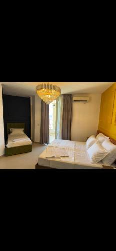 a bedroom with a large bed and a chandelier at Hotel Liburnia Vitamin Aga in Golem