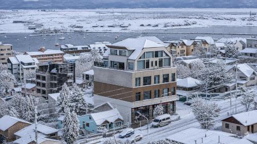 a city with snow covered roofs and buildings at Patagonia Home in Ushuaia