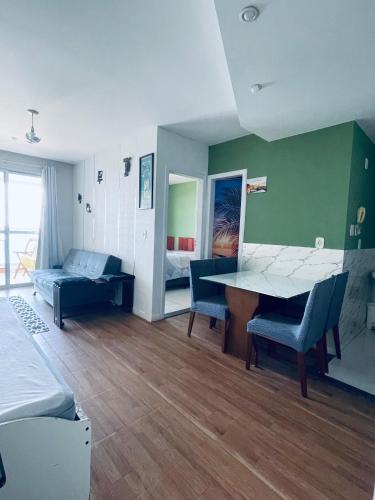 a room with a table and chairs and a bed at Frente Mar Green Diamond Residencial in Vila Velha