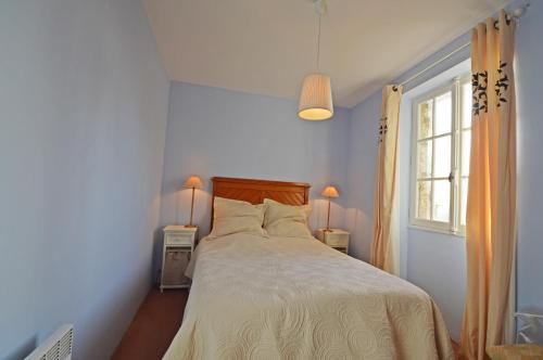 a bedroom with a bed with white sheets and a window at Mas Antonin in La Garde-Adhémar