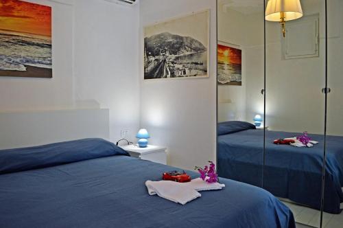 モネーリアにあるHouse Maestrale by Holiday Worldのベッドルーム1室(青いシーツと鏡付きのベッド2台付)