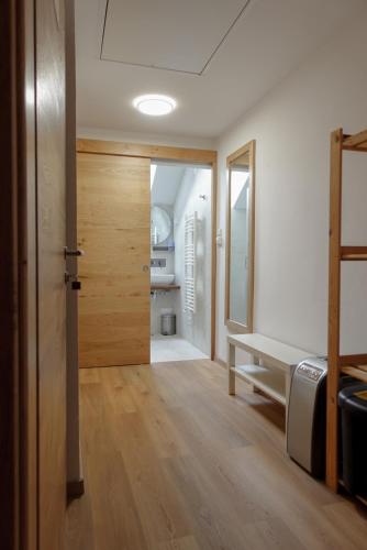 a hallway with a door and a room with a bench at Rooms Pevc & Hostel Ljubno ob Savinji in Ljubno