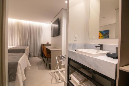 un bagno con lavandino e letto di Hotel Mandu a Teresina