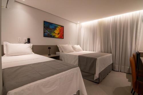 una camera d'albergo con due letti e una finestra di Hotel Mandu a Teresina